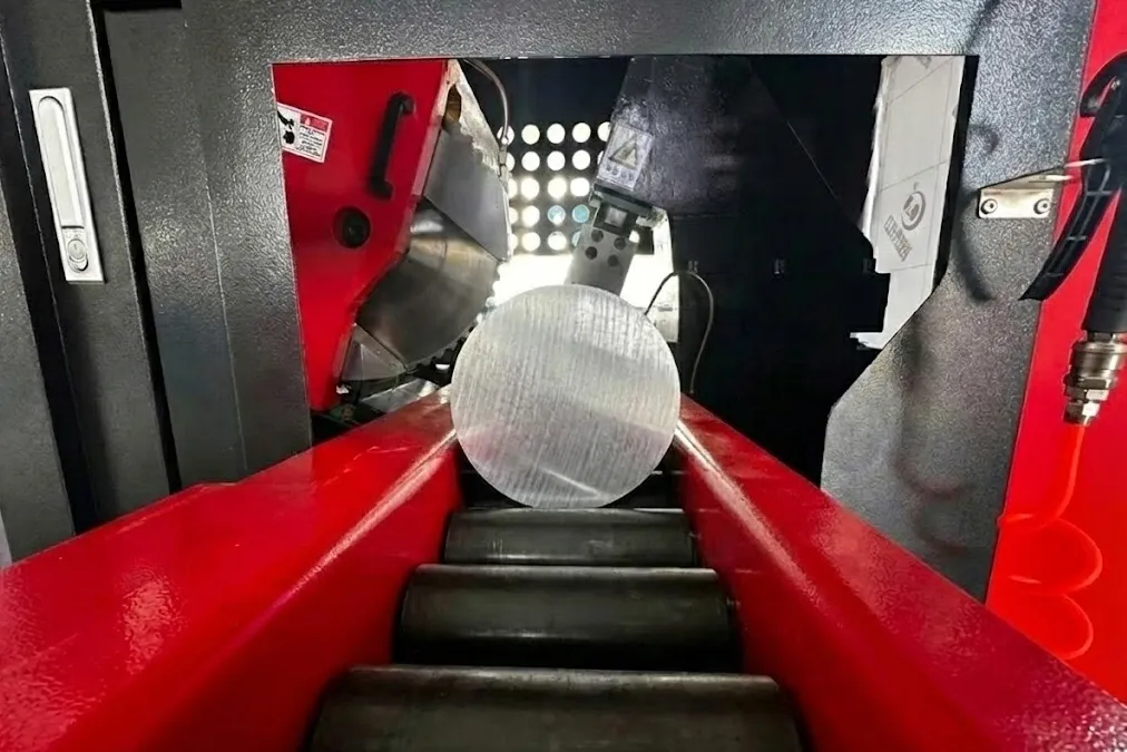 Heineda C6 cutting machine close-up of cutting head and metal bar on roller conveyor in action
