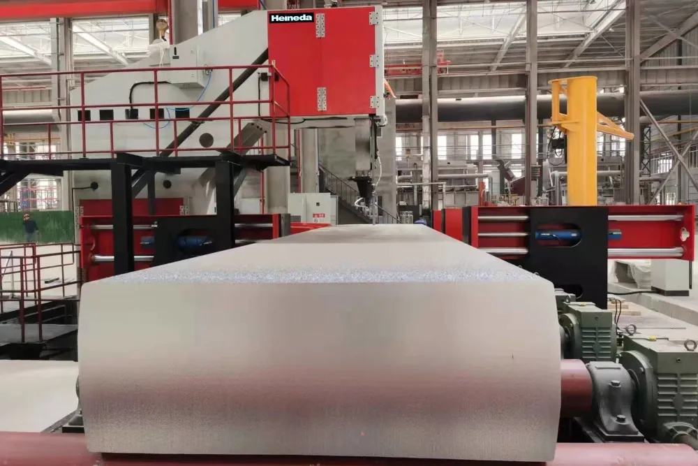 Heineda vacuum heat treatment furnace with large cylindrical workpiece on roller conveyor in industrial facility